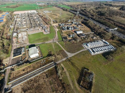 Aerial view of National Grid Sundon Substation, where metallic structures contrast with the surrounding green fields, Luton, United Kingdom.