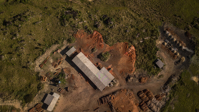 Aerial view of a building surrounded by red dirt and lush green vegetation, Rorainopolis, Roraima, Brazil.
