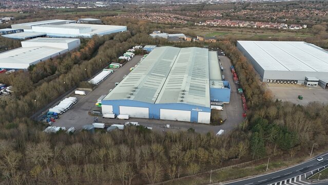 Morrisons, United Kingdom - 14 February 2026: Aerial view of the Morrisons Distribution Centre, a vast expanse of metallic roofs contrasted by the natural hues of the surrounding trees..
