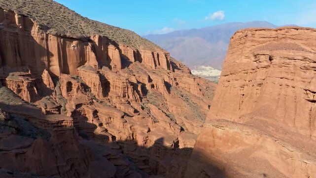 Drone view of eroded sandstone cliff in Konorchek canyons in Kyrgyzstan at dusk.