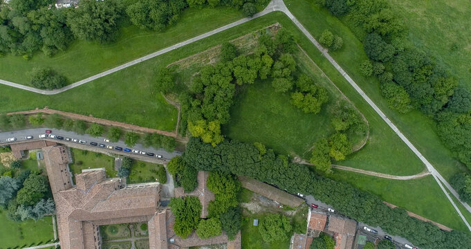 Aerial view of the contrast between the green fortress walls and the red rooftops of the buildings, Ferrara, Emilia-Romagna, Italy.
