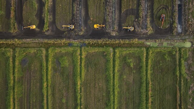 Aerial view of earthmoving machinery carving into the landscape, a testament to human intervention amidst nature's canvas, West Palm Beach, Florida, United States.