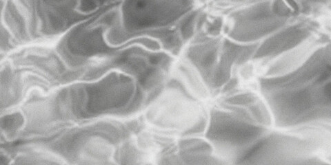 Abstract black and white image of rippling water surface with dynamic light reflections high...