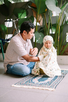Muslim Father Guides Young Daughter in Daily Prayer Ritual at Home