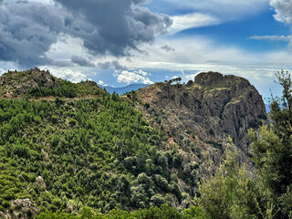 Mountainous landscape with valley and various mountains on the Mediterranean coast of Corsica in summer