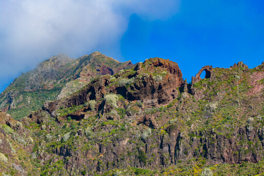 Aerial tracking shot over the rugged Anaga Massif peaks and the prehistoric barrancos of Punta del Hidalgo