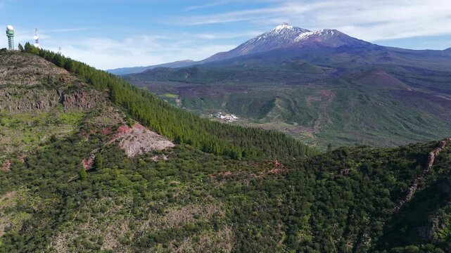 Aerial panorama of Mount Teide volcano summit rising above the Corona Forestal pine tree canopy in Tenerife