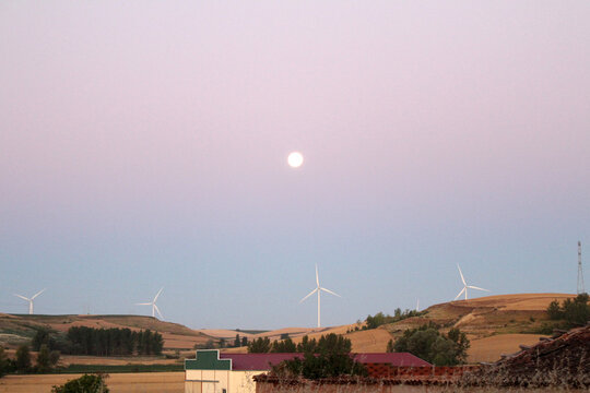 Sunrise over dirt path and windmill and full moon in Rabe de las Calzadas July 2024