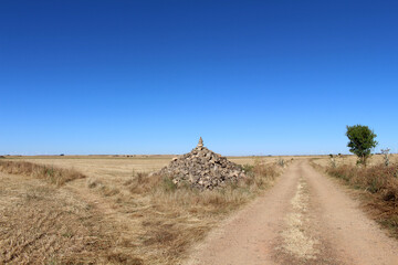 Fototapeta premium Dirt path and stacked stones near Hornillos del Camino in 2024