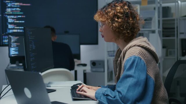 Concentrated Asian AI Programmer and Machine Learning Developer Focused on Screen, Writing code, Working on website development, software developing project in software company office.