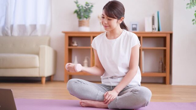 ダンベルを使って筋トレをする女性