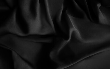 Obraz premium Luxury silk satin fabric background. Fashion elegant dark shade of white, grey and black. Smooth monochrome surface. Waves on the crumbled material. Abstract folds with shine. Dark smoke iron, jet