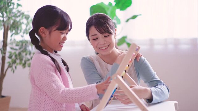 そろばんで遊ぶ園児と保育士