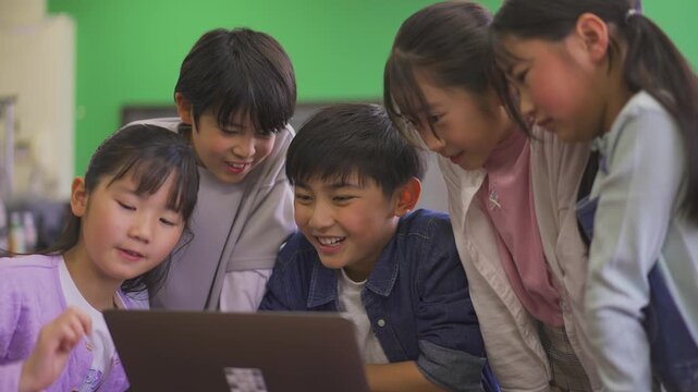 パソコンを囲む小学生