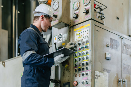 Technician skill worker man working control operate metal press machine in heavy industry factory