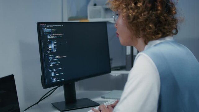 Concentrated Asian AI Programmer and Machine Learning Developer Focused on Screen, Writing code, Working on website development, software developing project in software company office.