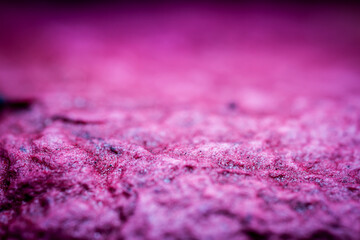 Extreme close up of purple handmade paper clay with a structure and rough texture. Paper recycling. Selective soft focus, shallow depth of field.