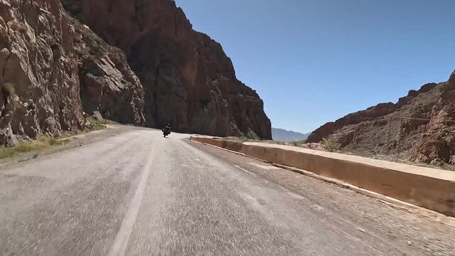 Driving behind a motorcycle in todra gorge, morocco