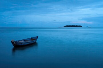 Fototapeta premium Tranquil blue hour ocean scene with a small boat and distant island silhouette