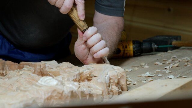 Woodcraft with tools, Skilled artisan carving wood amidst modern and traditional instruments, Hand sculptor engaged in detailed woodworking using range of vintage and contemporary tools