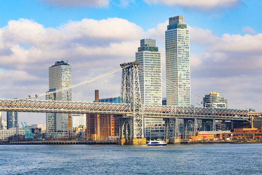 Williamsburg Bridge spanning East River with One Domino Square skyscrapers in Brooklyn New York City skyline at daytime