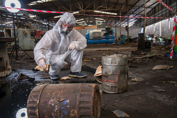 person in mask. Hazardous control related to factory chemicals. Employees are disposing of harmful substances. in a chemical protective suit in a factory	
