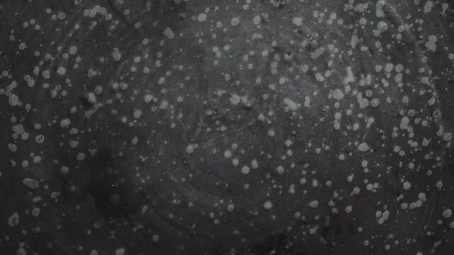 Texture light spots are reflected on a dark surface, creating a pattern. The effect is noticeable in low light, making the details stand out clearly.