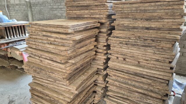 Professional RAW eye level wide shot of stacked wooden pallets for brick manufacturing in a factory in Bangladesh, 4K UHD 30fps.