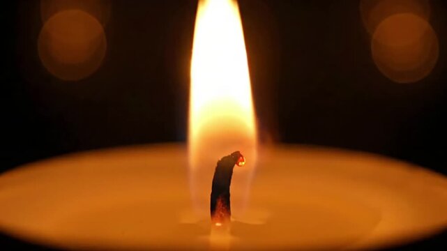 Ambient Candlelight Medium shot of a small cluster of burning candles, creating a warm, diffused glow that subtly illuminates an otherwise dark, undefined space.