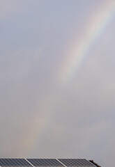A rainbow is seen in the sky above a solar panel