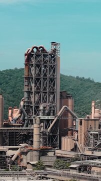 Industrial cement factory plant against hills