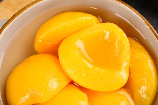 Canned Yellow Peach Halves in Syrup - Fresh Preserved Fruit in White Bowl