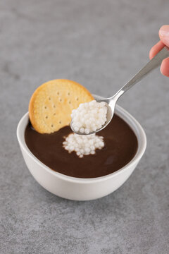 Coconut spherification pearls on chocolate dessert with spoon