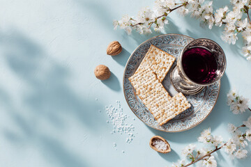 Passover  with matzo, red wine and spring blossoms on blue background. Flat lay, copy space