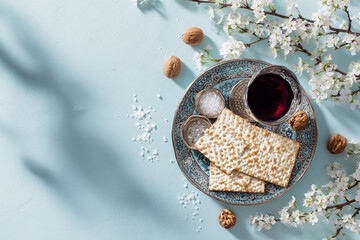 Passover  with matzo, red wine and spring blossoms on blue background. Flat lay, copy space