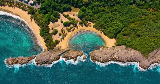 Iconic sandy beaches surrounded by lush greenery. Turquoise water rolls to the sunny shore. Manati Beach in Puerto Rico. Top view.