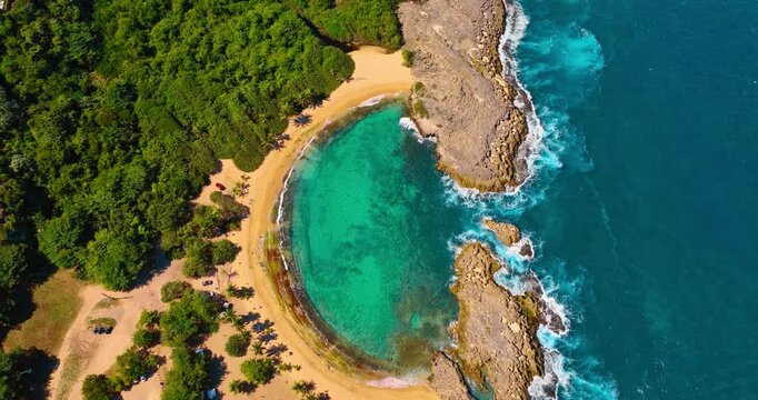 Amazing turquoise water at the semicircle beach in Manati, Puerto Rico. Beautiful lush greenery surrounds the scenery. Top view.