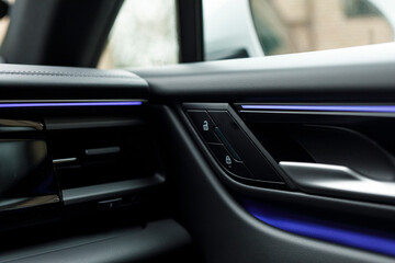 Naklejka premium Close-up shot of a car door handle with illuminated accents. Focus on luxury design and detail, sleek dashboard aestheti