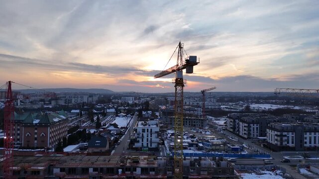 Construction Cranes at Sunset Over Urban Development Site