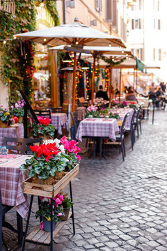 Cozy outdoor restaurant terrace on a narrow cobblestone street in Europe