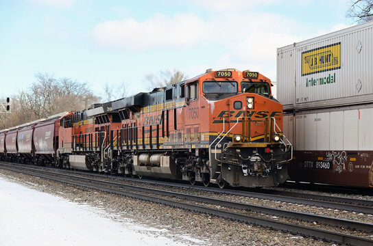 Burlington Northern Santa Fe freight trains pass in Chicago's southwest suburbs. At left, a westbound grain train passes an eastbound stack train bound for BNSF's Cicero Yard.