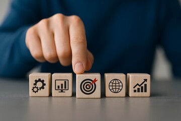 Naklejka premium Hand points to a wooden block with a target icon, emphasizing business goals and focused achievement.
