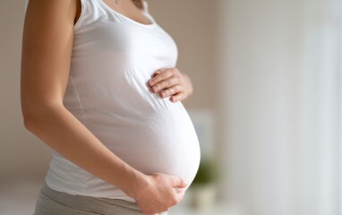 Close-Up of Pregnant Woman&rsquo;s Belly Showing Baby with Gentle Touching Hands