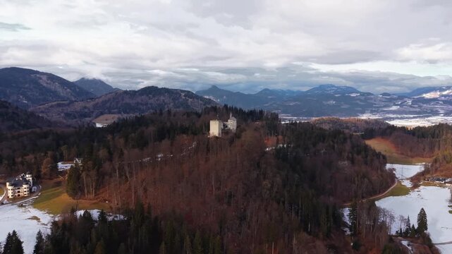 Aerial drone view. Winterliche Luftaufnahme von Thierbergkapelle und Burg Thierberg. Mittelalterliche Festung auf einem Huegel mit Aussicht auf Inntal und umliegende Alpen. Tyrol, Austria. 