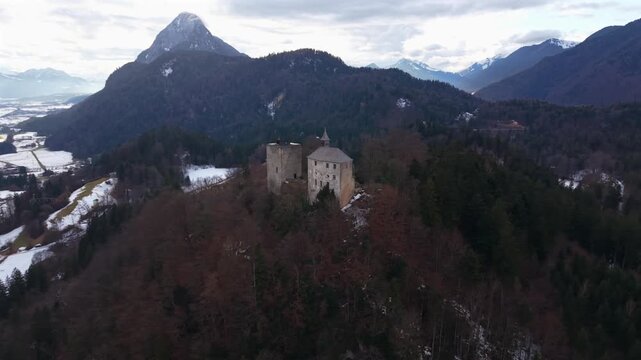 Luftbildvideo von Burg Thierberg in Tirol, Oesterreich. Verschneite Burgruinen und Kapelle mit weitem Blick ueber das Inntal und alpine Gipfel. Austrian Alps. Near Kufstein, Tyrol, Austria.