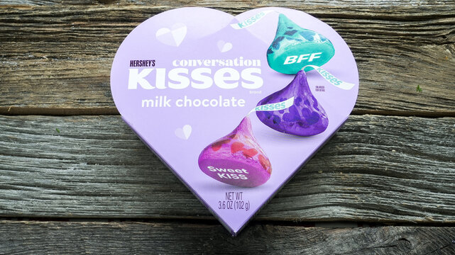 NORWALK, CT, USA - FEBRUARY 20, 2026:A heart-shaped box of Hershey's chocolate kisses is on a wooden table. The box features colorful wrappers and labels. The setting is simple and showcases the produ
