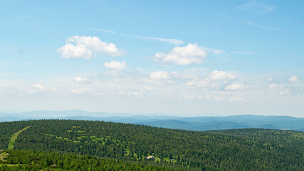 Panorama zalesionych gór pod jasnym letnim niebem. © Lidia