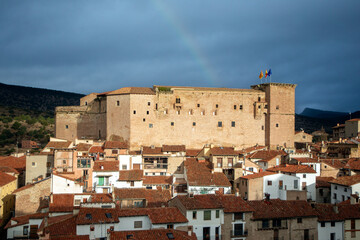 Mora de Rubielos Castle in Teruel, Aragon, Spain, with the town at its feet and a rainbow in the sky