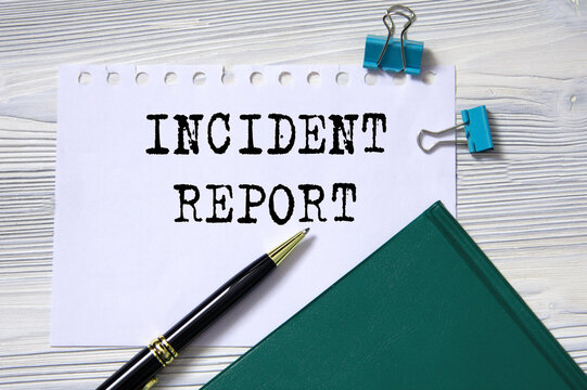 INCIDENT REPORT - words in white paper on the background of a diary, glasses and pen
