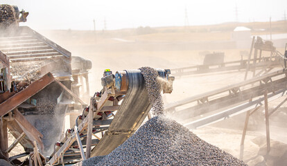 Plakat Vibrating screen stone crusher in operation. Crushing stones in a quarry for processing minerals, cement, limestone. Heavy and mobile equipment in a quarry for processing stone into building material.